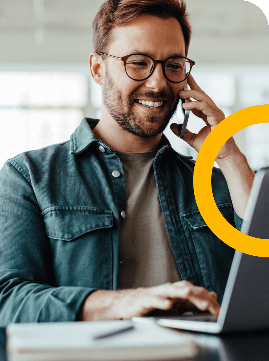 Man working on laptop while taking a phone call